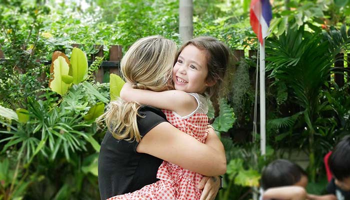 Happy child and teacher hug at British Early Years Centre International kindergarten in Bangok